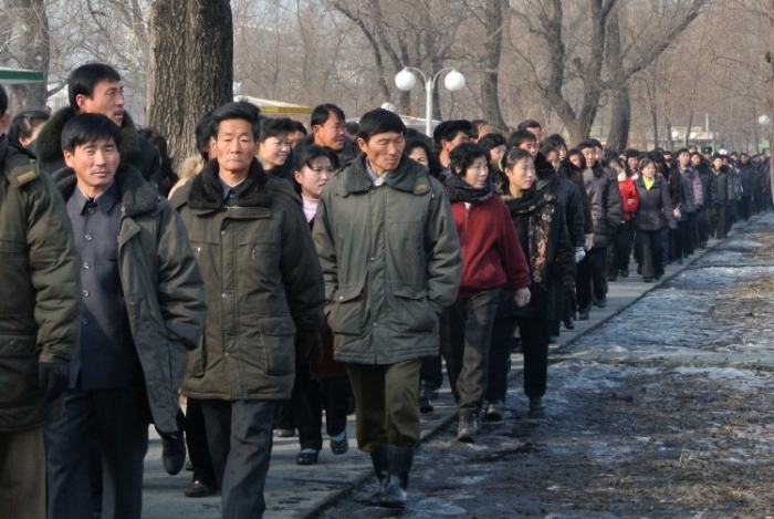 Lucrători nord-coreeni încolonaţi după terminarea zilei de muncă la o fabrică din apropierea oraşului de frontieră, Sinuiju, pe 15 decembrie 2012 (Wang Zhao / AFP / Getty Images)