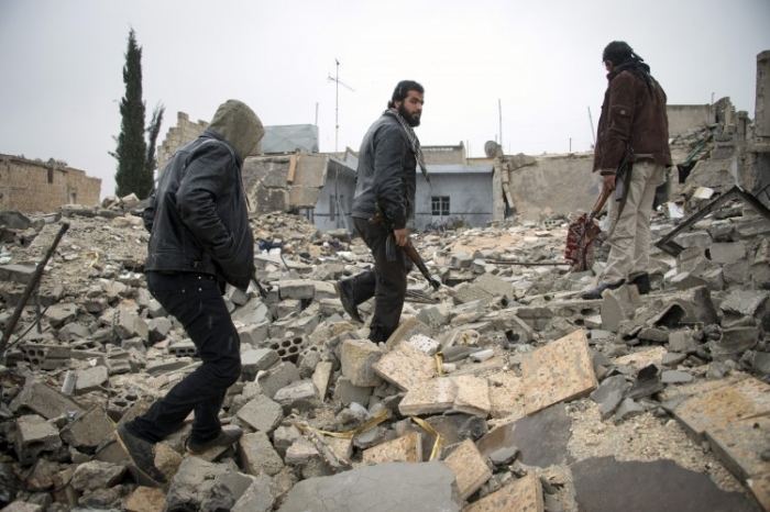 Soldati rebeli merg prin molozul unei clădiri din nordul oraşului sirian Alep, 6 decembrie 2012