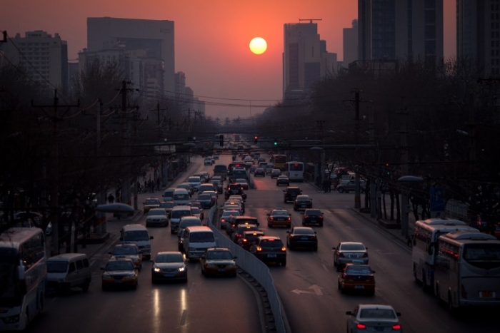 Soarele apune peste traficul din Beijing, pe 25 martie 2012
