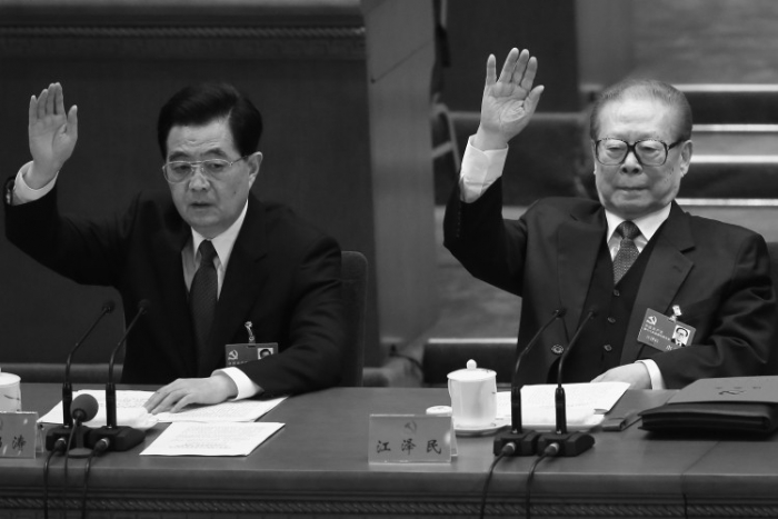 Foştii lideri ai Partidului Comunist Chinez Hu Jintao şi, respectiv Jiang Zemin ridicând mâna în timpul sesiunii de închidere a celui de-al 18-lea Congres al Partidului din 14 noiembrie 2012.