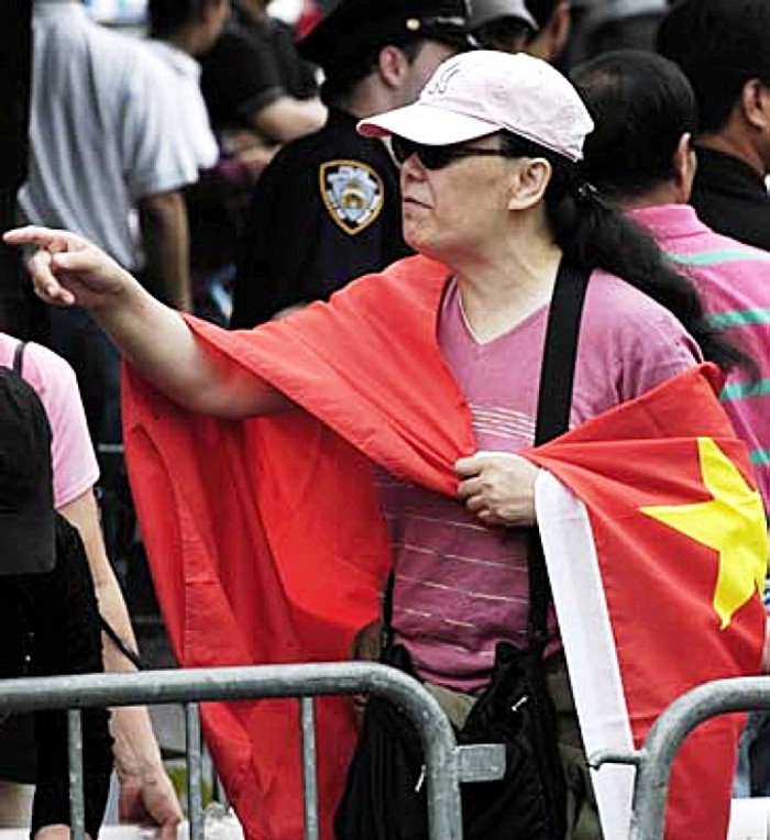 Li Huahong înfăşurată într-un steag al regimul chinez la 31 mai 2008, în Flushing. Li este cunoscută pentru răspândirea propagandei în rândul chinezilor din Flushing.