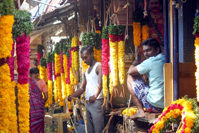 Doi bărbaţi împletesc ghirlande în piaţa de flori în Puducherry, India, 15 ianuarie 2013.