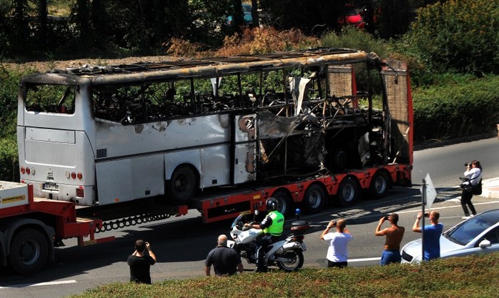 Un camion tractând un autobuz afectat de explozia sinucigaşă care a vizat un grup de turişti israelieni pe aeroportul din Burgas, Bulgaria, la 19 iulie 2012. (Nikolay Doychinov / AFP / GettyImages)