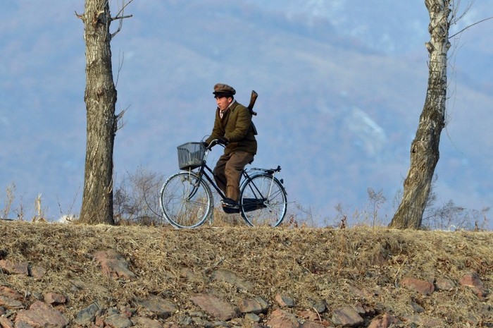 Un soldat nord coreean patrulează pe bicicletă de-a lungul râului Yalu 12 februarie 2013.