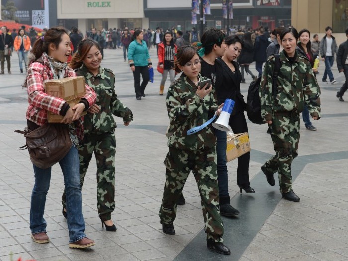 Femeile chineze în uniformă sunt văzute mergând pe jos la 4 februarie 2013 prin zona centrală a oraşului Chongqing, după apariţia anunţului recent conform căruia echipele speciale de poliţie de sex feminin, înfiinţate de membrul căzut în dizgraţie Bo Xilai, vor fi desfiinţate. Mass-media chineze de stat au raportat că Chongqing a acumulat datorii uriaşe sub conducerea lui Bo, fapt ce poate fi o pregătire pentru un proces public al lui Bo privind acuzaţii de corupţie în cursul acestui an. (MARK RALSTON / AFP / Getty Images)