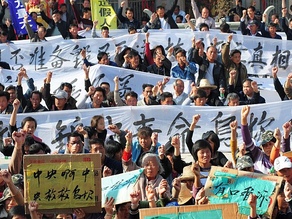 Sătenii ţin banere în timpul unui miting de protest al rezidenţilor din Wukan, un sat de pescari din provincia de sud Guangdong, solicitând luarea unor măsuri împotriva confiscării ilegale de terenuri şi moartea în custodie a unui lider local, la 19 decembrie 2011. Profesorul Xie Yielang de la Universitatea Beijing, citând cifrele interne ale regimului, a declarat că în 2009, în China, au existat 230.000 de incidente în masă - revolte sau proteste cu mai mult de 50 de persoane, o indicaţie a instabilitaţii sociale în creştere a Chinei.