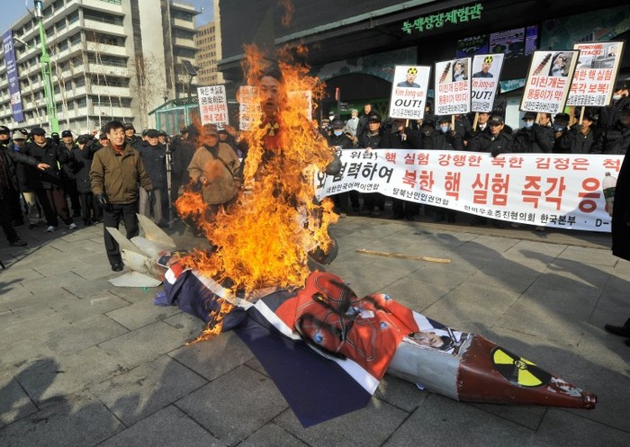 Sud coreeni ard poze ale liderului coreean Kim Jong-Un la un miting în Seul 13 februarie 2013.