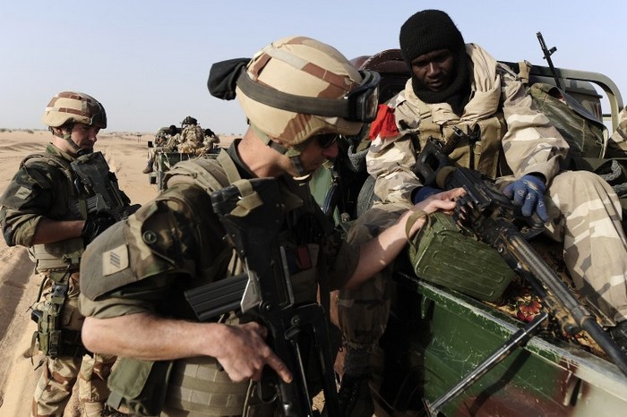Un soldat francez (stânga) se uită la arma unui soldat din Mali în timp ce intră în Bourem, nordul Mali, 17 februarie 2013.