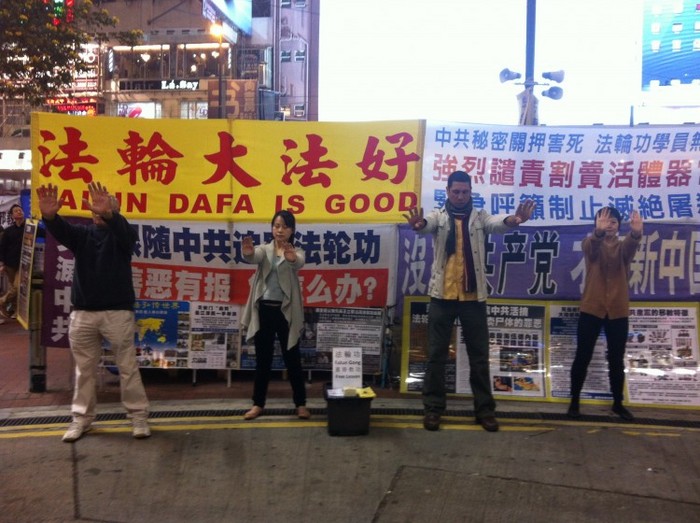 Miguel Fernandez (al doilea din dreapta) practică exerciţiile Falun Gong la un punct de informare din Hong Kong, la începutul lunii ianuarie 2013. Fernandez a fost arestat de poliţia din Hong Kong pentru că a dat jos banerele Asociaţiei de Îngrijire a Tineretului din Hong Kong care atacau Falun Gong.