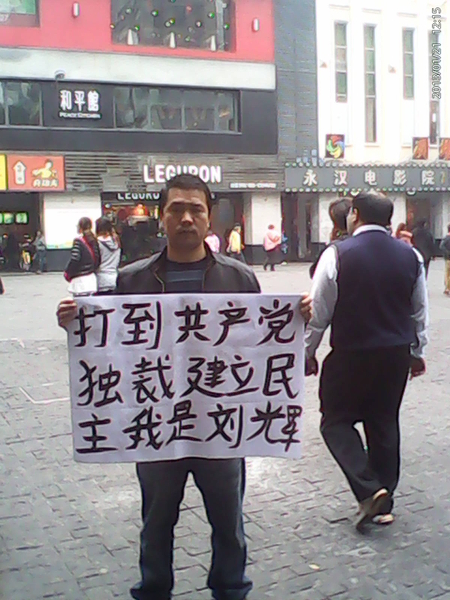 Liu Hui în Guangzhou la 13 şi 14 februarie, ţinând bannere pe care scria "Terminaţi dictatura" şi "Eliminarea robiei oamenilor de către partid" (Courtesy of the subject)
