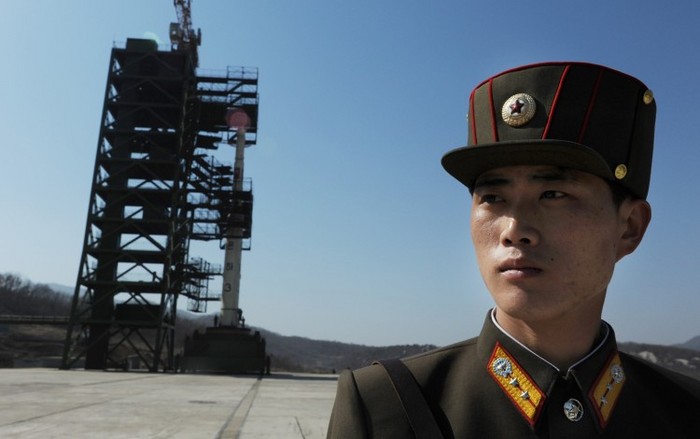 Un soldat nord-coreean stă de pază în faţa unui rachete Unha-3 la centru spaţial de la Tangachai-ri, 8 aprilie 2012. La 17 aprilie racheta cu rază lungă de a fost lansată, dar s-a rupt în bucăţi înainte de a părăsi atmosfera terestră.