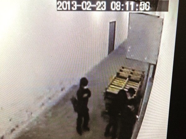 O secvenţă luată cu o camera de securitate prezintă trei oameni cu măşti negre care încearcă să deschidă uşa tipografiei ziarului The Epoch Times din Hong Kong pe 23 februarie. (Epoch Times)