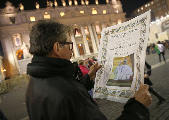 Un om citeşte o ediţie specială a ziarului L'Osservatore Romano, care are o fotografie al Papei nou ales Francisc I, în Vatican pe 13 martie.