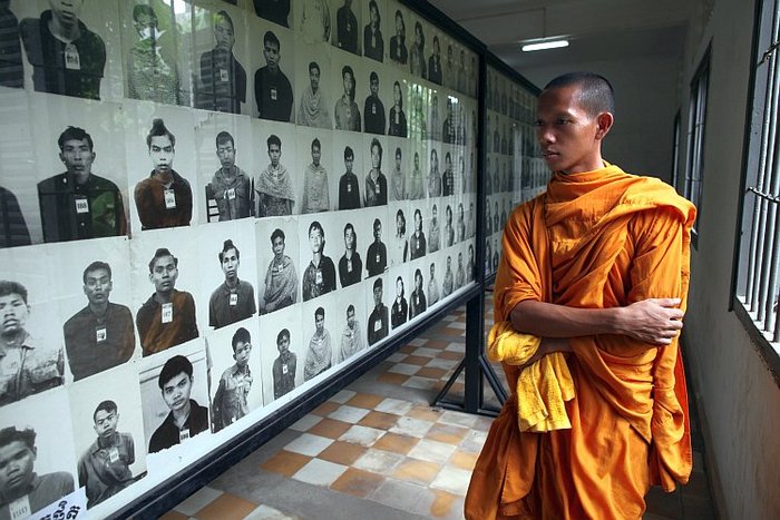 Călugăr cambogian priveşte fotografiile victimelor regimului Khmerilor Roşii, la închisoarea S-21 devenită acum muzeul Toul Sleng în Phnom Penh, Cambogia.