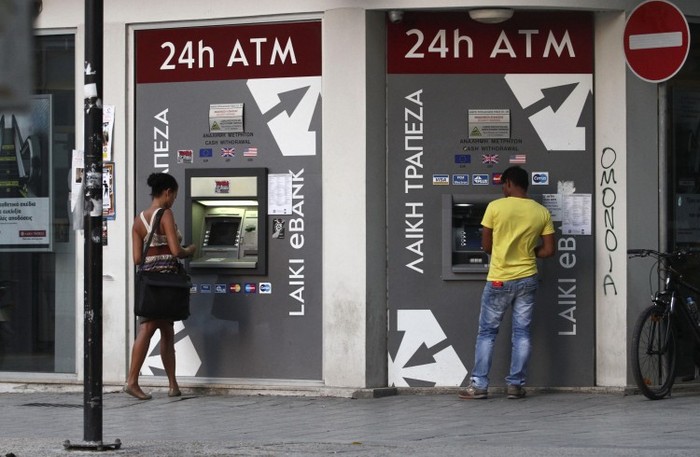 Oamenii retrag bani de la un bancomat al băncii Laiki, din capitala cipriotă Nicosia (Yiannis Kourtoglou / AFP / GettyImages)