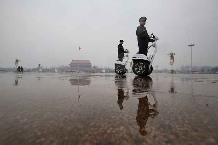 Doi poliţişti conduc vehicule electronice de patrulare cu două roţi, în Piaţa Tiananmen, la 12 martie 2013, în Beijing.