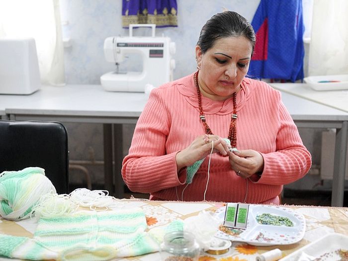 Karima Mohammad (D), care conduce Centrul Naţiunilor Unite pentru Integrarea Refugiaţilor în Kiev, Ucraina, tricotează la sediu. Tricotajul este o sursă de venit pentru refugiaţii din Ucraina. (Vladimir Borodin / The Epoch Times)