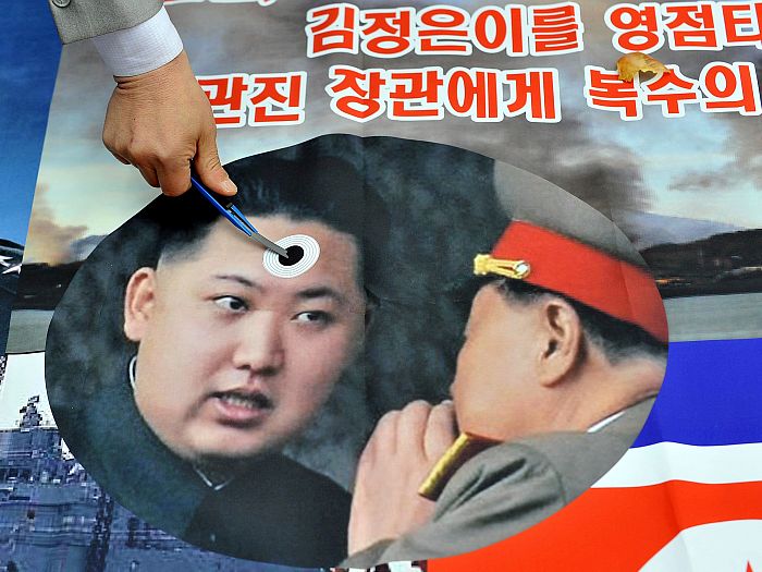 Un activist sud-coreean desenează pe o poză a tânărului lider nord-coreean Kim Jong Un.