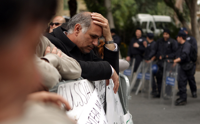 Un angajat al Băncii cipriote Laiki participă la un protest în faţa Parlamentului în Nicosia, Cipru, în 22 martie 2013.