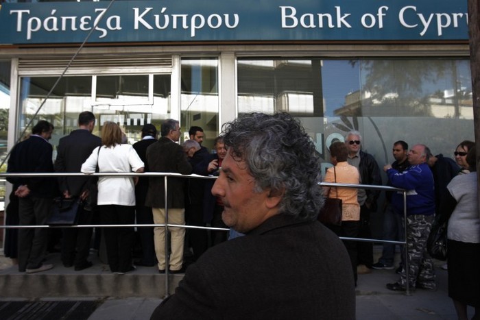 Oamenii asteaptă în faţa unei sucursale a Băncii Ciprului din Nicosia, la 28 martie. Băncile din Cipru au fost redeschise joi pentru clienţi, după aproape două săptămâni.
