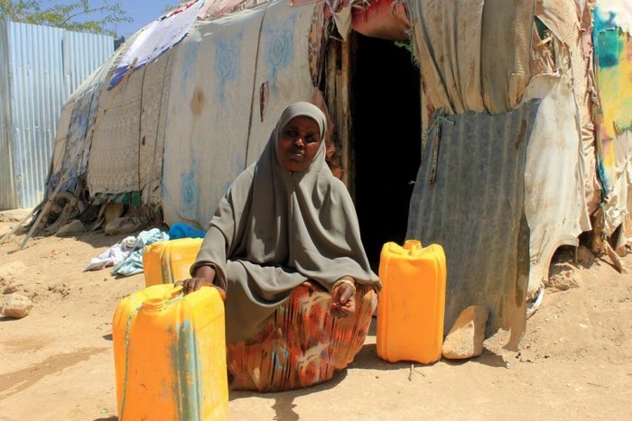 
O femeie stă in faţă casei sale din satul etiopian de Darwanaji, în districtul Awbarre în apropiere de graniţa cu Somalia, înconjurată de recipiente cu apă galbene omniprezente într-o societate în care apa este întotdeauna solicitată
