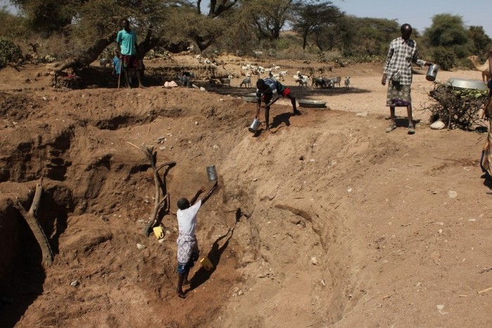 Bărbaţii extrag apa dintr-o fântănă de adâncime mică făcută într-un râu în Gogti, Etiopia.