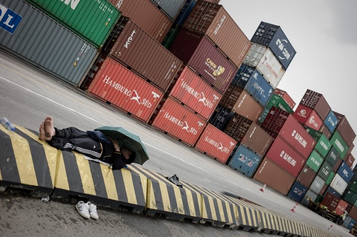 Un docher se odihneşte în faţa terminalului de containere Kwai Chung din Hong Kong, la 29 martie 2013. (Philippe Lopez / AFP / Getty Images)