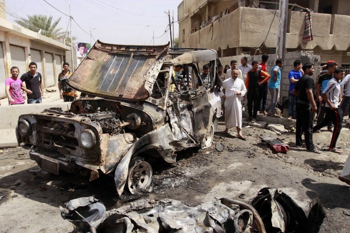 Civilii irakieni se adună la scena unui atac cu o maşină capcană în cartierul estic Kamaliya din Bagdad, luni, 15 aprilie 2013. (AP Photo /  Khalid Mohammed)