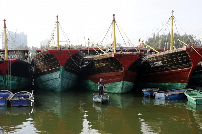 Un pescar chinez stă în faţa navelor de pescuit, în oraşul maritim Tanmen, din provincia din sudul Chinei Hainan, la 21 ianuarie 2013. Beijing-ul pretinde o fâşie importantă din Marea Chinei de Sud, care are o importanţă strategică, iar pescarii din Hainan şi agenţiile de turism sunt în prima linie a conflictului. (Wang Zhao / AFP / Getty Images)