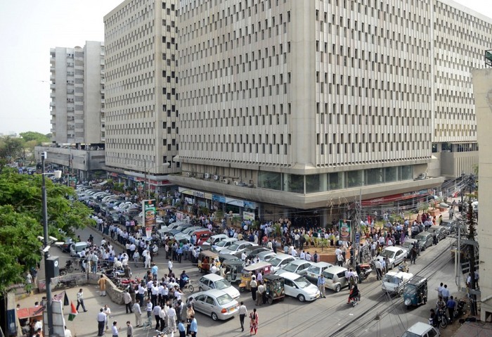 Mai mulţi pakistanezi sunt fotografiaţi după ce au evacuat clădirile din apropiere în Karachi, 16 aprilie 2013.