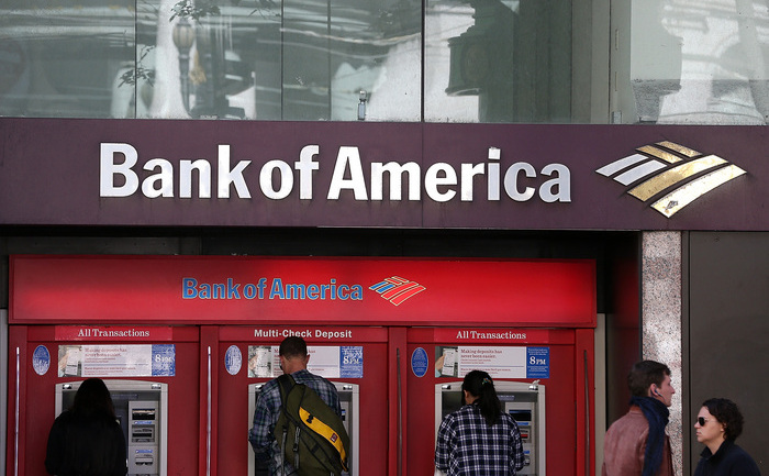 Clienţii folosesc un bancomat la o filială a Bank of America din San Francisco, California.
