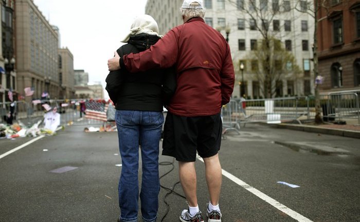 Doi oameni privesc către locul producerii atentatului de la maratonul din Boston, 20 aprilie 2013. (TIMOTHY A. CLARY / AFP / Getty Images)