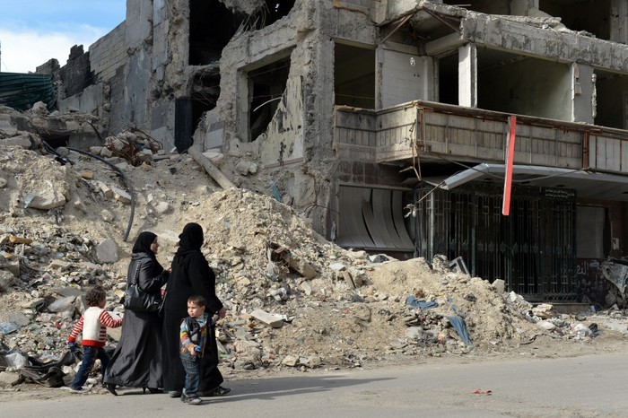 Femei siriene trec pe langă ruinele spitalului Al-Shifa în nordul oraşului Alep pe 21 aprilie 2013.