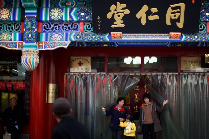 Rezidenţi chinezi ies dintr-o farmacie Tongrentang, celebra farmacie de medicina chineză tradiţională, pe o alee din zona Qianmen la 16 martie 2008, la Beijing, China.