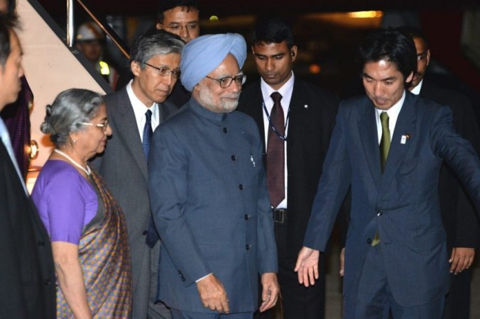 Prim-ministrul indian Manmohan Singh, însoţit de soţia sa Gursharan Kaur, este întâmpinat de un oficial japonez, la sosirea sa la Tokyo International Airport pe 27 mai 2013. (Yoshikazu Tsuno / AFP / Getty Images)