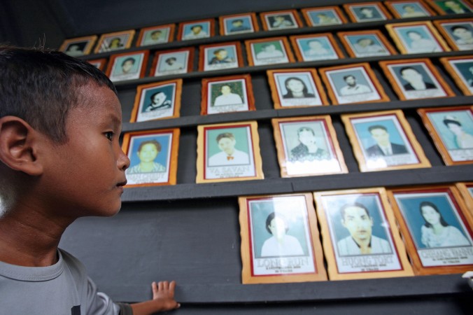 Orfanul cambodgian, Chang Saron, se uită la portretele victimelor SIDA la ONG-ul "Parteneri Cambodgieni în Compasiune" (PCC), în provincia Takeo, la aproximativ 45 de kilometri sud de Phnom Penh (Tang Chhin Sothy / AFP / Getty Images)