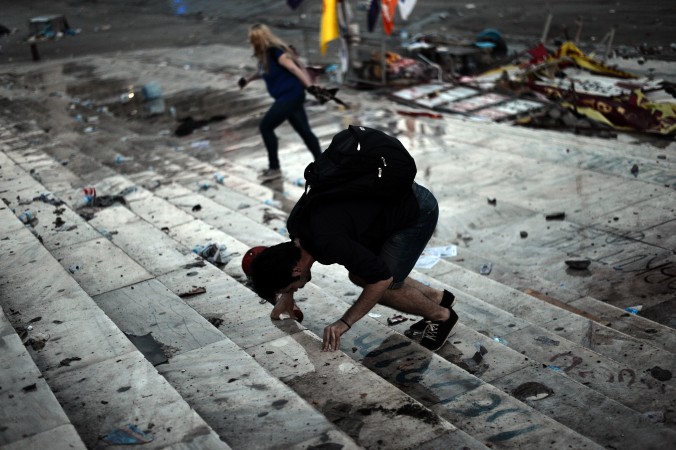 Un protestatar reacţionează la gazele lacrimogene din timpul ciocnirilor din Piaţa Taksim din Istanbul, la 11 iunie 2013