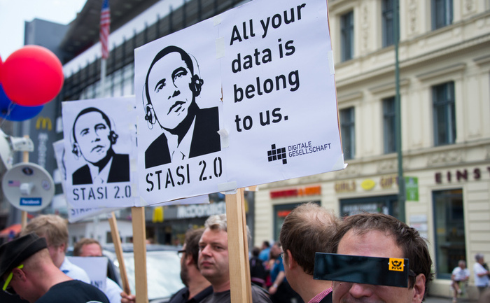 Protestatari ţin pancarde care îl înfăţişează pe Barack Obama cu căşti, purtând textul „Stasi 2.0” făcând aluzie la practicile de spionaj şi monitorizare ale fostei poliţii secrete est germane „Stasi”, 18 iunie 2013, la Berlin, unde Obama este aşteptat în vizită.