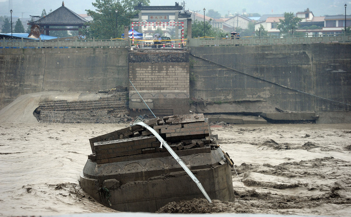 Ruins of the collapsed Panjiang bridge, also called Qinglian bridge, are seen in the flooded river in Sichuan's Jiangyou city, southwest China's Sichuan province on July 9, 2013.  Witness said about ten vehicles fell into the torrent when the nearly 50-year-old bridge broke apart just before noon, the Sichuan online News reported.  CHINA OUT     AFP PHOTO        (Photo credit should read STR/AFP/Getty Images)