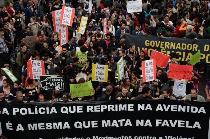 Manifestanţi blochează Brasil Avenue, principala strada de acces în Rio de Janeiro, în faţa Complexului Favelas de Mare, în timpul unui protest din 2 iulie 2013 împotriva violenţei aplicate de poliţia militarizată.