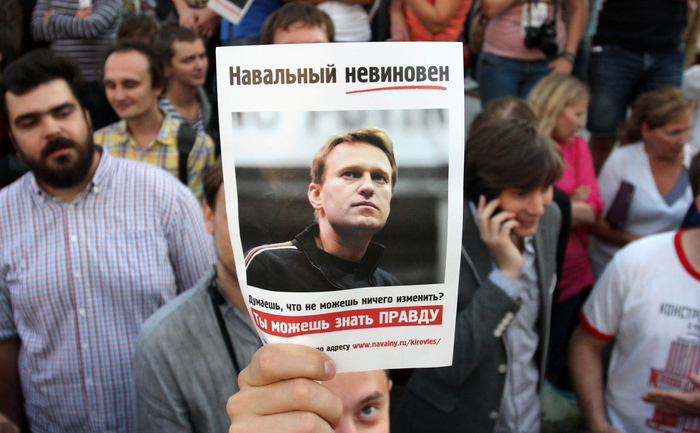 Un protestatar ţinând poza lui Alexei Navalnîi, în timpul unei demonstraţii din centrull Moscovei, iulie 2013