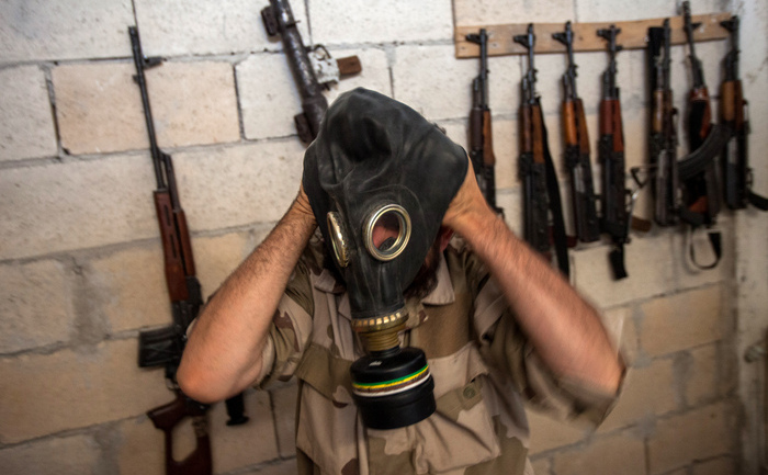 Un rebel sirian încearcă o mască de gaze confiscată de la o fabrică a armatei siriene în provincia nord-vestica Idlib la 18 iulie 2013