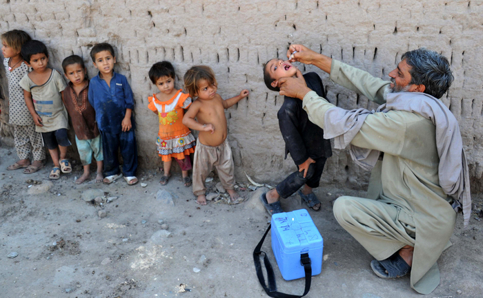An Afghan health worker (R) administers polio vaccine drops to a child during the first day of a vaccination campaign on the outskirts of Jalalabad, Nangarhar province on July 1, 2013. Polio, once a worldwide scourge, is endemic in just three countries now - Afghanistan, Nigeria and Pakistan. AFP PHOTO/Noorullah Shirzada        (Photo credit should read Noorullah Shirzada/AFP/Getty Images) (Noorullah Shirzada / AFP / Getty Images)