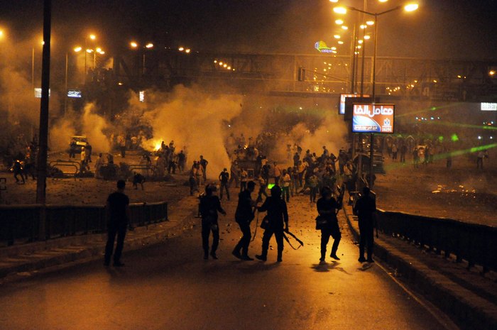 Susţinători egipteni ai preşedintelui egiptean destituit, Mohamed Morsi (în spate) în conflict cu poliţia din Cairo, în dimineaţa zilei de 27 iulie 2013.