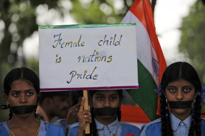 
Eleve din India ţin o pancartă şi participă la un protest tăcut din cauza violării unei fetiţe de 5 ani în New Delhi, în Hyderabad, India, la 23 aprilie 2013
