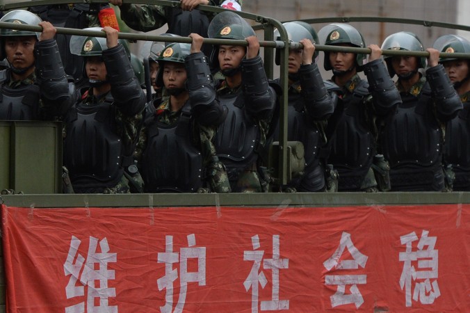 
Forţe chineze paramilitare de poliţie sunt aduse cu camioanele în timpul unei desfăşurări de forţă în Urumqi în provincia Xinjiang, la 29 iunie 2013.
