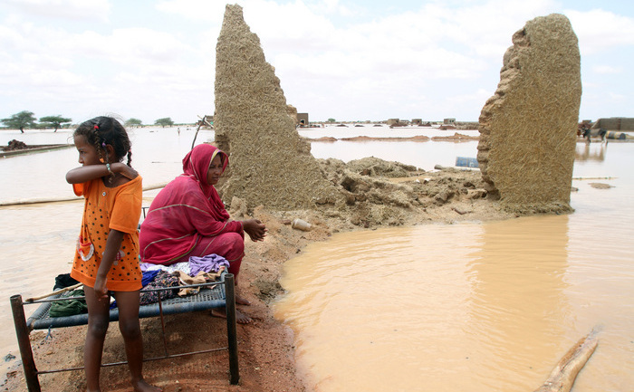 O femeie sudaneză se află lângă casa ei pe o stradă inundată, la marginea capitalei Khartoum pe 10 august 2013. Drenajul este slab în capitală deci chiar şi un pic de ploaie poate provoca inundaţii, dar inundaţiile din acest an au fost neobişnuit de severe.
