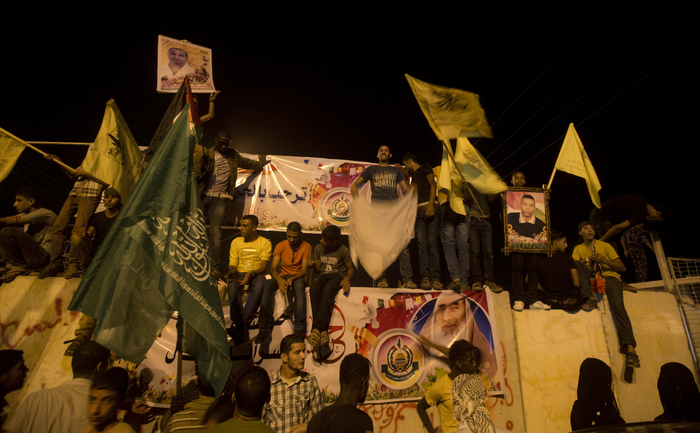 
Palestinienii sărbătoresc în timp ce aşteaptă sosirea prizonierilor eliberaţi în apropiere de punctul de frontieră Erez, între Israel şi nordul Fâşiei Gaza, 14 august 2013.