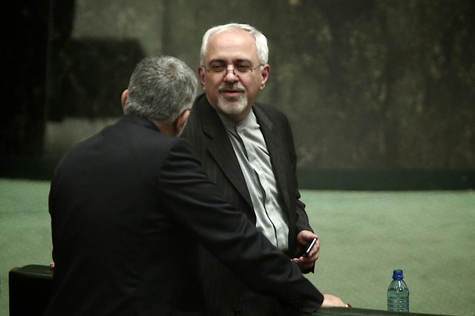 Nominalizat pentru Ministrul de Externe iranian, Mohammad Javad Zarif, vorbeste cu un deputat în timpul unei sesiuni a Parlamentului de la Teheran la 15 august 2013. Zarif a fost confirmat de parlament în aceeaşi zi. (Behrouz Mehri / AFP / Getty Images)