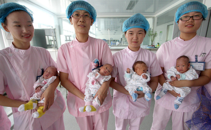 Asistente medicale tinand in brate 4 gemeni, intr-un spital din Lianyungang, in Estul Chinei, in provincia Jiangsu, 17 August 2011. (STR / AFP / Getty Images)